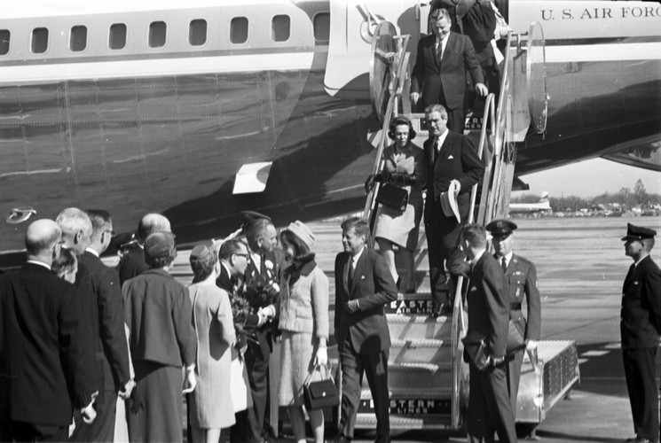 An image of JFK descending the steps of the airplane on his final trip to Dallas, Texas